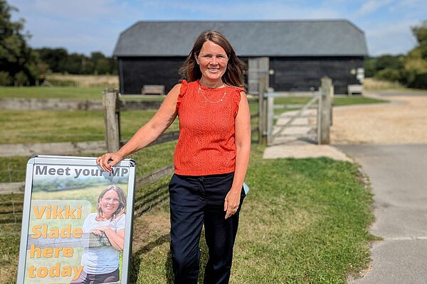 Vikki stood next to a sign advertising one of her surgeries
