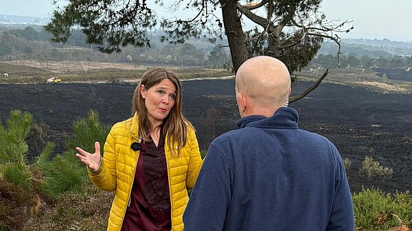 Vikki being interviewed in front of burned heathland