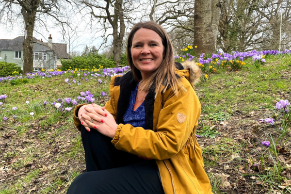 Vikki sat on the ground amongst some flowers